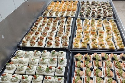 Plateau de canapés variés sur pain blanc, garnis de légumes, herbes fraîches et condiments colorés.