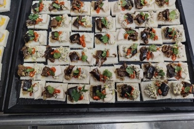 Plateau de canapés variés sur pain blanc, garnis de légumes, herbes fraîches et condiments colorés.