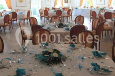 Chambre classique avec lit double, mobilier en bois, rideaux dorés et lumière naturelle entrant par une fenêtre.