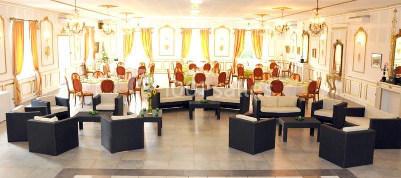 Salle élégante avec mobilier moderne et chaises classiques, décorée de rideaux colorés et de lustres.