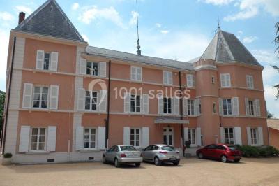 Chambre classique avec lit double, mobilier en bois, rideaux dorés et lumière naturelle entrant par une fenêtre.