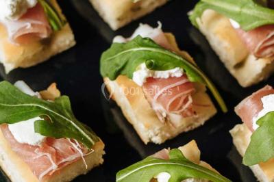 Miniature Traiteur Paris (Paris) - Profumo Traiteur Italien #4 Des personnes discutent en petits groupes lors d'un événement dans une salle élégante avec des vitraux et une fresque murale.