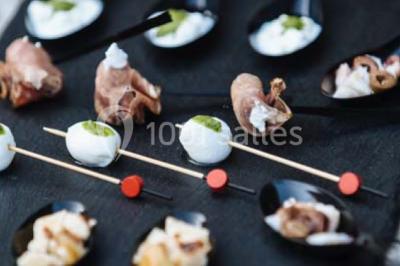Des personnes discutent debout lors d'un événement dans une salle élégante avec des vitraux et une fresque murale.