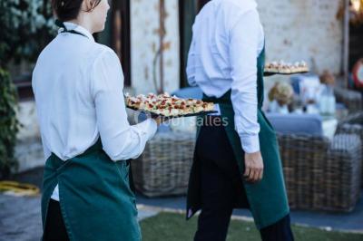 Des personnes discutent debout lors d'un événement dans une salle élégante avec des vitraux et une fresque murale.