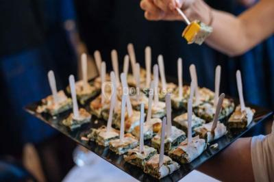 Des personnes discutent debout lors d'un événement dans une salle élégante avec des vitraux et une fresque murale.