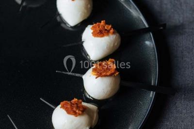 Des personnes discutent debout lors d'un événement dans une salle élégante avec des vitraux et une fresque murale.