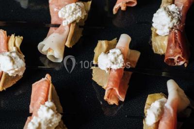 Des personnes discutent debout lors d'un événement dans une salle élégante avec des vitraux et une fresque murale.