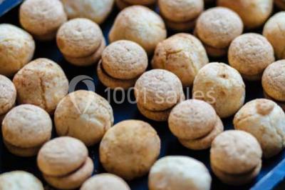 Des personnes discutent debout lors d'un événement dans une salle élégante avec des vitraux et une fresque murale.