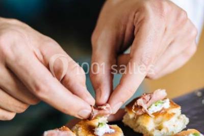 Des personnes discutent debout lors d'un événement dans une salle élégante avec des vitraux et une fresque murale.