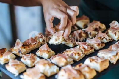 Des personnes discutent debout lors d'un événement dans une salle élégante avec des vitraux et une fresque murale.