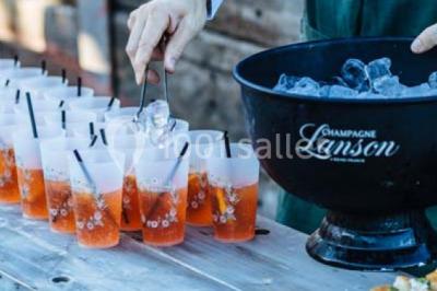Des personnes discutent debout lors d'un événement dans une salle élégante avec des vitraux et une fresque murale.