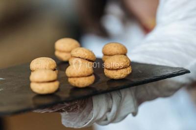 Des personnes discutent debout lors d'un événement dans une salle élégante avec des vitraux et une fresque murale.