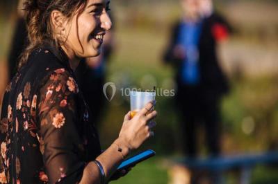 Des personnes discutent debout lors d'un événement dans une salle élégante avec des vitraux et une fresque murale.
