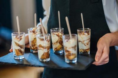 Des personnes discutent debout lors d'un événement dans une salle élégante avec des vitraux et une fresque murale.