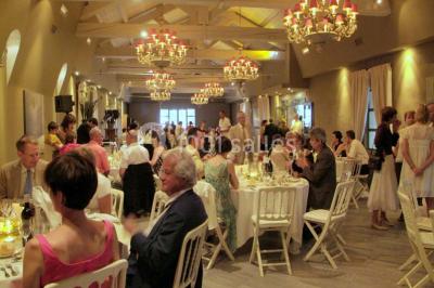 Terrain de tennis entouré d'arbres et de végétation, avec un olivier au premier plan.