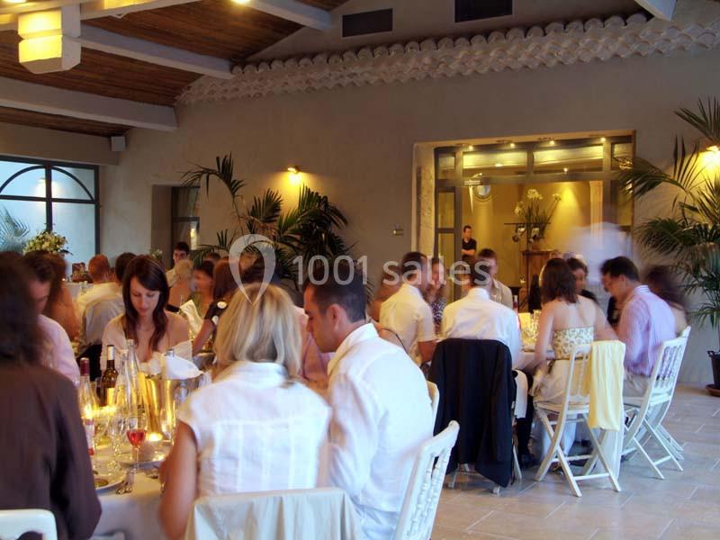 Des convives assis autour de tables dans une salle lumineuse avec des plantes et un décor chaleureux.