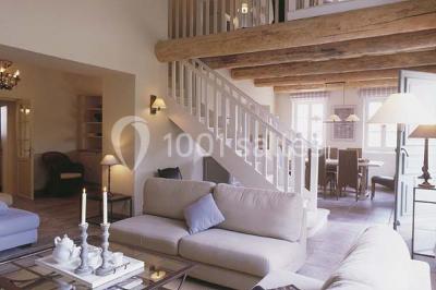 Terrain de tennis entouré d'arbres et de végétation, avec un olivier au premier plan.