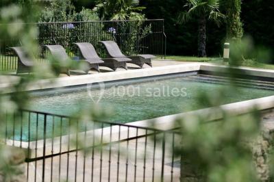 Terrain de tennis entouré d'arbres et de végétation, avec un olivier au premier plan.