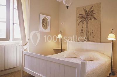 Terrain de tennis entouré d'arbres et de végétation, avec un olivier au premier plan.