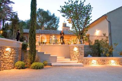 Terrain de tennis entouré d'arbres et de végétation, avec un olivier au premier plan.