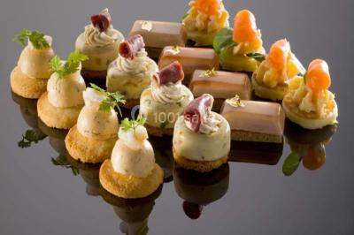 Plateau de petits canapés variés garnis de légumes, fromage, œufs de poisson et décorations colorées.