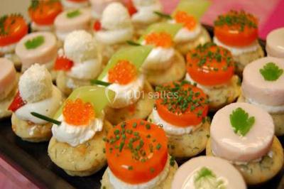 Plateau de petits canapés variés garnis de légumes, fromage, œufs de poisson et décorations colorées.