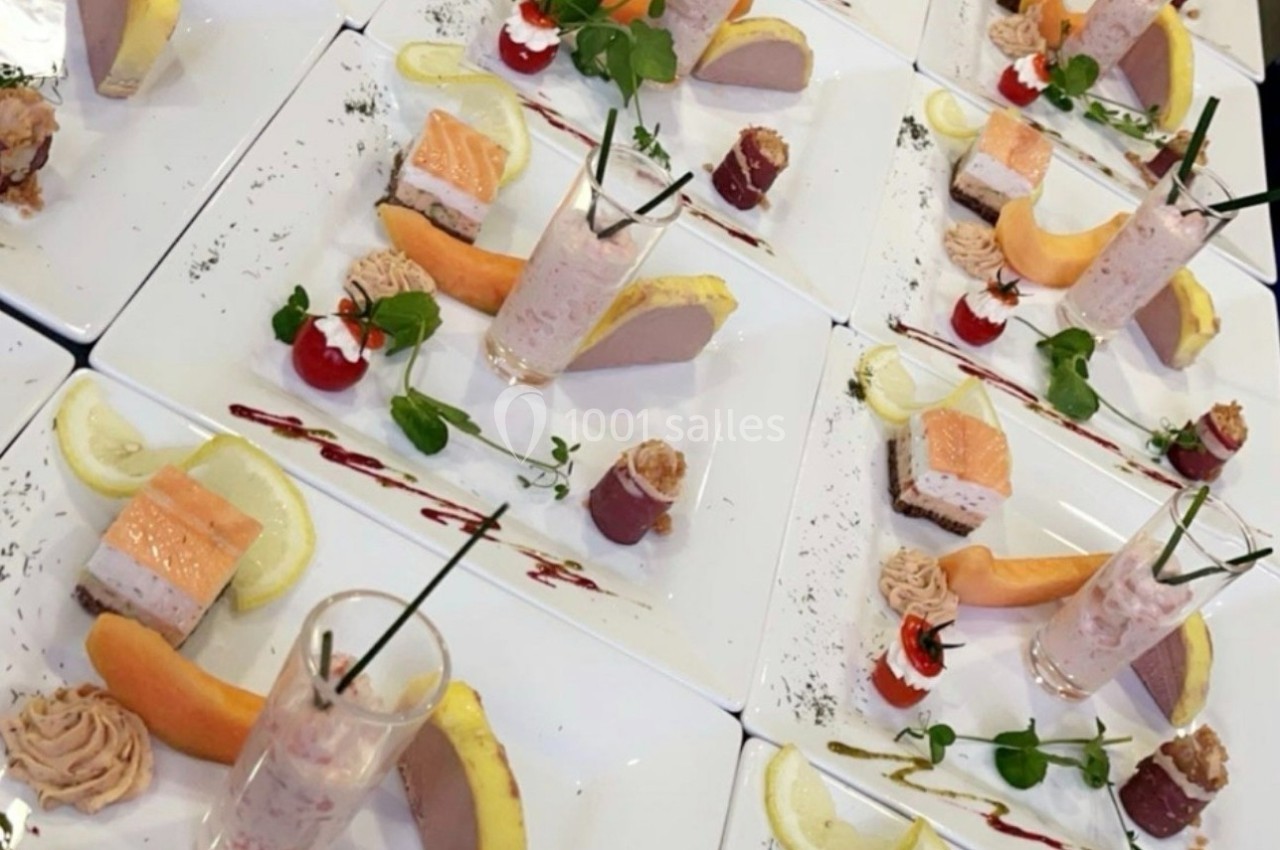 Assiettes dressées avec des entrées variées : mousse, saumon, verrine, fruits et décorations raffinées.
