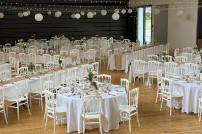 Miniature Traiteur Yffiniac (Côtes-d'Armor) - Walle Traiteur #11 Salle de réception décorée avec des tables rondes et rectangulaires, nappes blanches, chaises blanches et guirlandes…