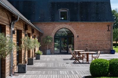 Banc en bois sous une arche décorée de feuilles d'automne, entouré de bougies et de feuilles au sol dans une salle rustique.