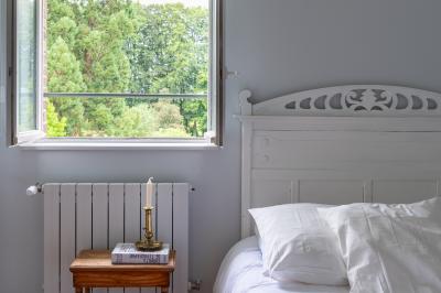 Banc en bois sous une arche décorée de feuilles d'automne, entouré de bougies et de feuilles au sol dans une salle rustique.
