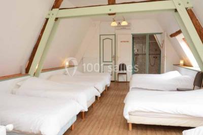 Miniature Location salle Argueil (Seine-Maritime) - Domaine de Clairval #29 Lit double avec tête de lit sombre, draps gris et blancs, encadré par deux tables de chevet avec lampes, dans une chambre…