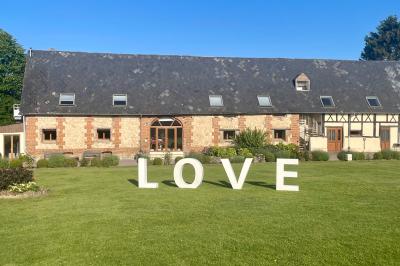 Miniature Location salle Argueil (Seine-Maritime) - Domaine de Clairval #6 Lit double avec tête de lit sombre, draps gris et blancs, encadré par deux tables de chevet avec lampes, dans une chambre…