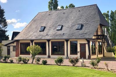 Miniature Location salle Argueil (Seine-Maritime) - Domaine de Clairval #8 Lit double avec tête de lit sombre, draps gris et blancs, encadré par deux tables de chevet avec lampes, dans une chambre…