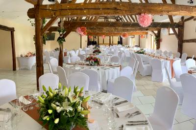 Miniature Location salle Argueil (Seine-Maritime) - Domaine de Clairval #10 Lit double avec tête de lit sombre, draps gris et blancs, encadré par deux tables de chevet avec lampes, dans une chambre…