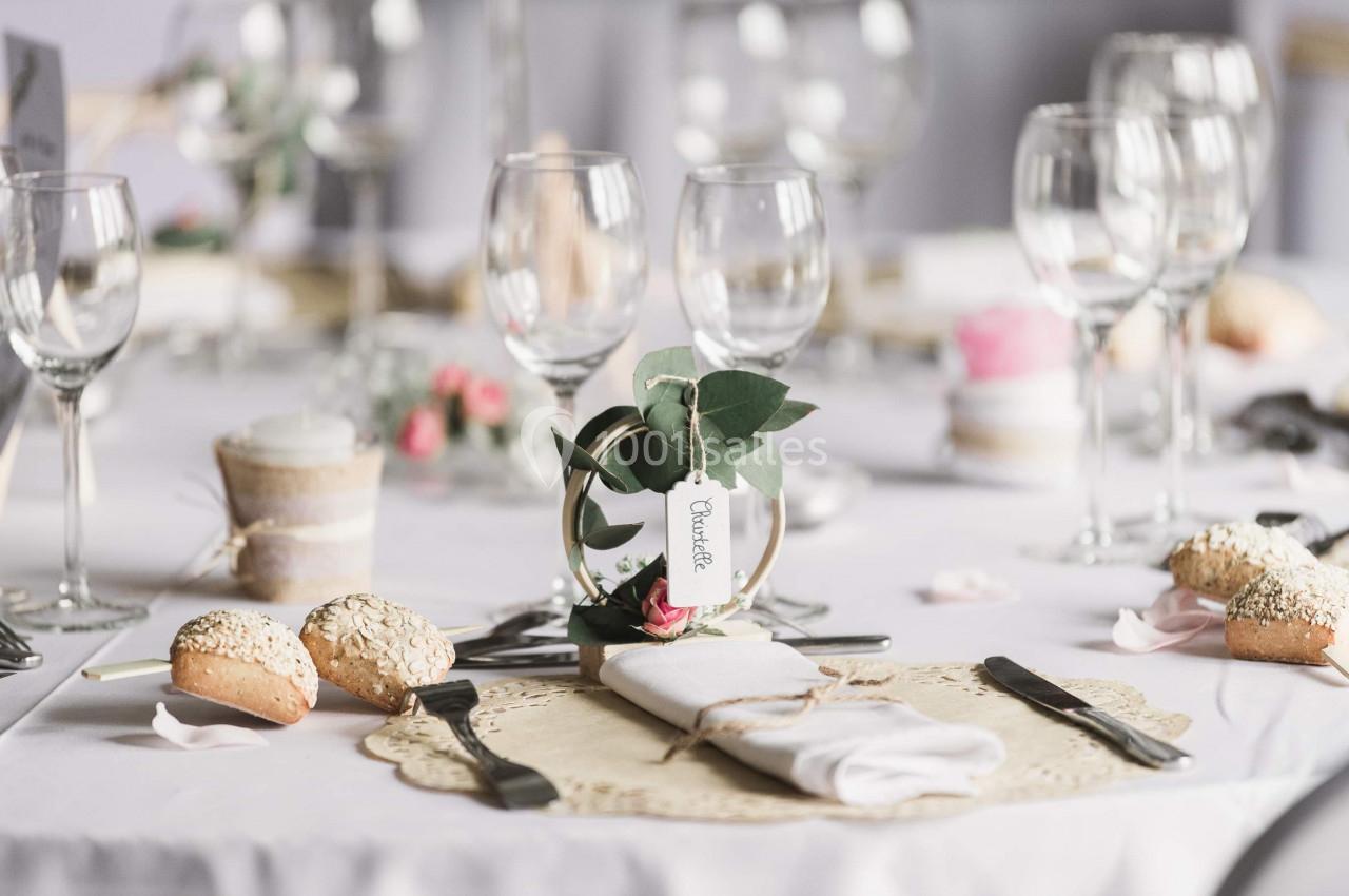 Location salle Argueil (Seine-Maritime) - Domaine de Clairval #11 Table dressée avec des verres, couverts, petits pains et une décoration florale au centre.