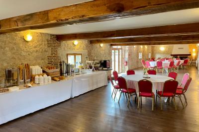 Miniature Location salle Argueil (Seine-Maritime) - Domaine de Clairval #13 Lit double avec tête de lit sombre, draps gris et blancs, encadré par deux tables de chevet avec lampes, dans une chambre…