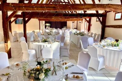 Miniature Location salle Argueil (Seine-Maritime) - Domaine de Clairval #18 Lit double avec tête de lit sombre, draps gris et blancs, encadré par deux tables de chevet avec lampes, dans une chambre…