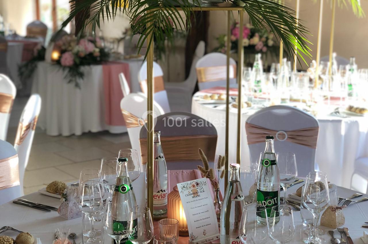 Location salle Argueil (Seine-Maritime) - Domaine de Clairval #17 Table de réception élégamment dressée avec décoration florale, nappes blanches, chemins de table roses et vaisselle raffinée.