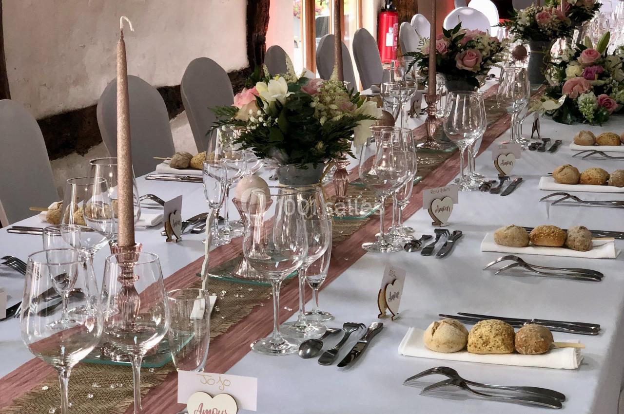 Location salle Argueil (Seine-Maritime) - Domaine de Clairval #16 Table de réception élégamment dressée avec nappes blanches, bouquets de fleurs, verres, couverts et petits pains.