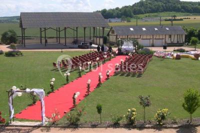 Miniature Location salle Argueil (Seine-Maritime) - Domaine de Clairval #21 Lit double avec tête de lit sombre, draps gris et blancs, encadré par deux tables de chevet avec lampes, dans une chambre…