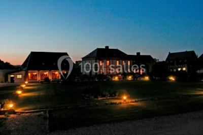 Miniature Location salle Argueil (Seine-Maritime) - Domaine de Clairval #24 Lit double avec tête de lit sombre, draps gris et blancs, encadré par deux tables de chevet avec lampes, dans une chambre…
