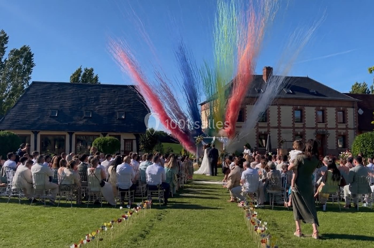 Cérémonie laïque - Fumigènes Cérémonie de mariage en plein air avec des invités assis et des jets de fumée colorée en arrière-plan.