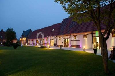 Miniature Grande Clairval de nuit Lit double avec tête de lit sombre, draps gris et blancs, encadré par deux tables de chevet avec lampes, dans une chambre…