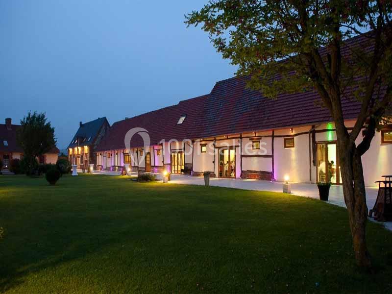 Grande Clairval de nuit Bâtiment à colombages éclairé en soirée, entouré d'une pelouse et d'arbres.