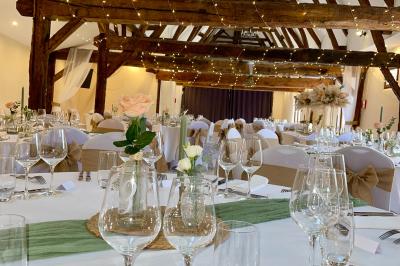 Miniature La Grande Clairval Lit double avec tête de lit sombre, draps gris et blancs, encadré par deux tables de chevet avec lampes, dans une chambre…