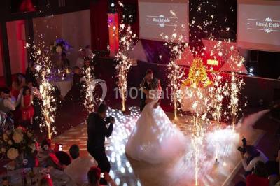 Un couple en tenue de mariage danse au milieu d'une salle de casino entourée de machines à sous.