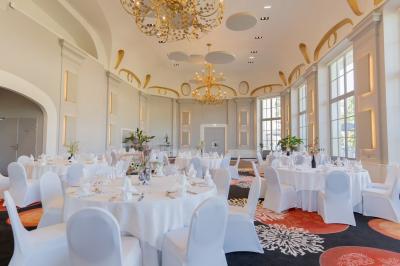 Un couple en tenue de mariage danse au milieu d'une salle de casino entourée de machines à sous.