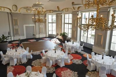 Un couple en tenue de mariage danse au milieu d'une salle de casino entourée de machines à sous.