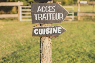Centre de table avec fleurs séchées dans un bol en céramique et une carte indiquant ’Table Amitié’ sur une rondelle de bois.