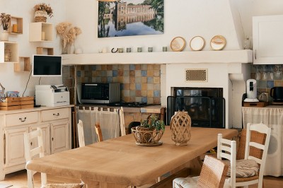 Centre de table avec fleurs séchées dans un bol en céramique et une carte indiquant ’Table Amitié’ sur une rondelle de bois.